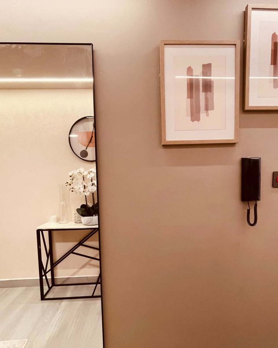 Entry console with an orchid and mirror in the finished studio